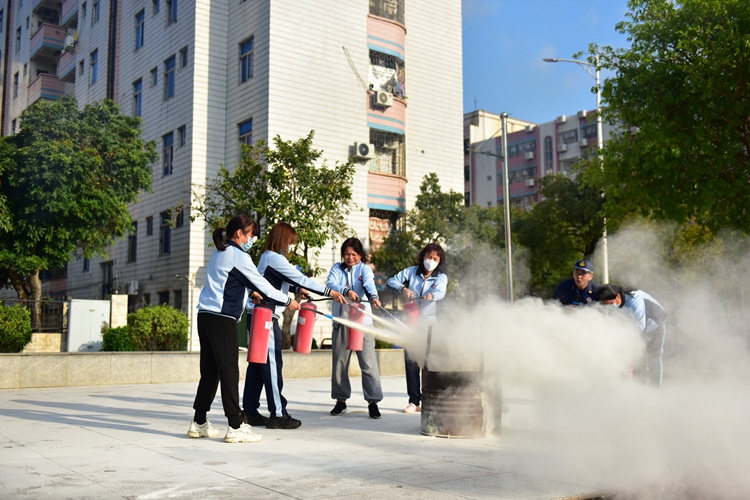 图9：生活老师学习操作灭火器.JPG